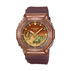 A Casio G-Shock watch with a brown resin band and case, featuring a digital display and analog hands.