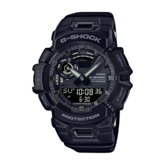 A black CASIO G-SHOCK GBA-900-1ADR watch with a digital display, analog hands, and multiple watch features visible.