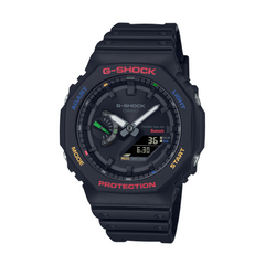 A black CASIO G-SHOCK watch with a digital display and analog hands, featuring a carbon case and resin band.