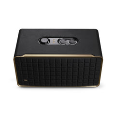A black JBL Authentics 500 Bluetooth speaker with a premium aluminum frame and a custom leather-like enclosure. It features a visible downfiring woofer and the JBL logo at the front.