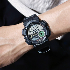 Digital wristwatch on a person's wrist with a dark background