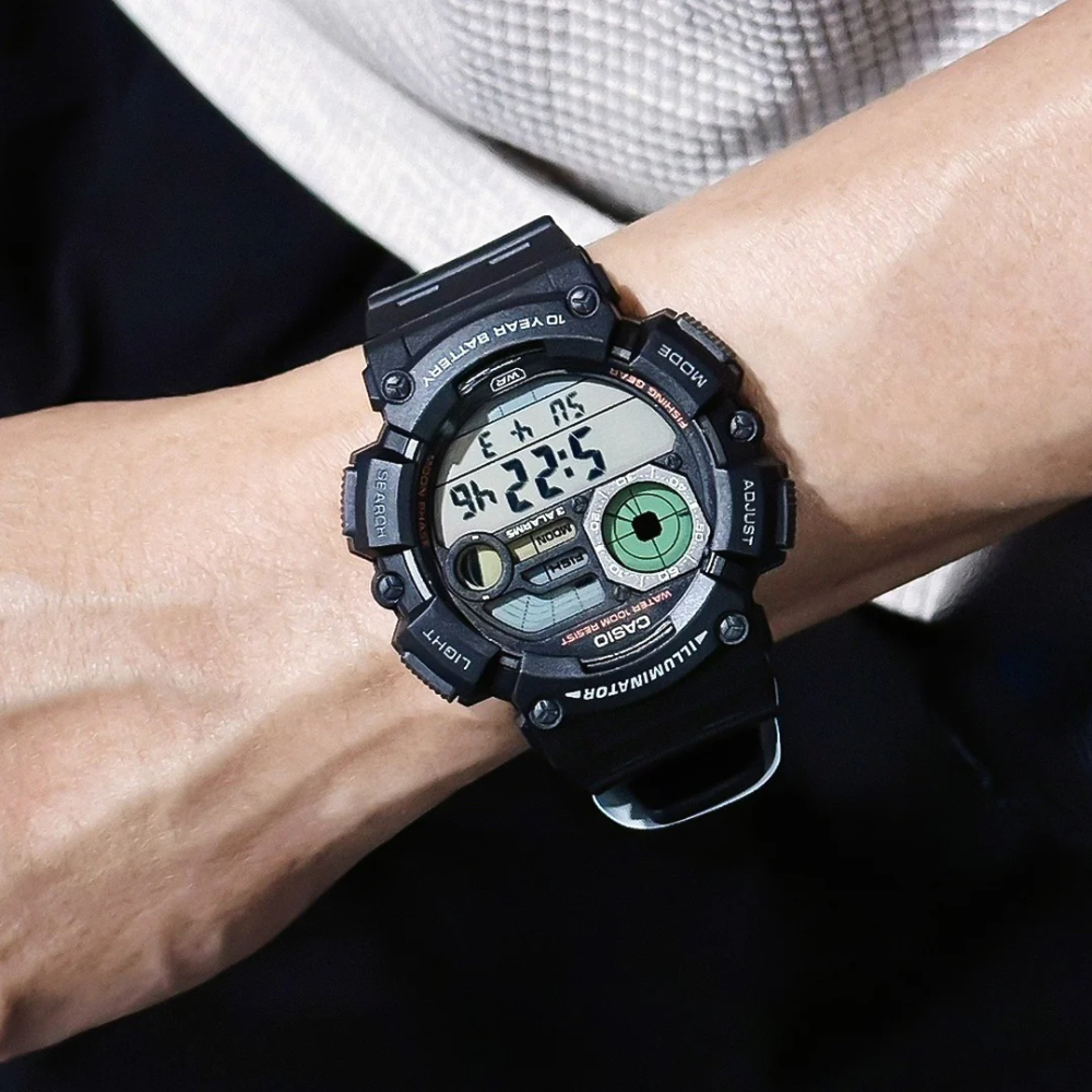 Digital wristwatch on a person's wrist with a dark background